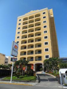 un gran edificio amarillo con un cartel delante en Hotel Bello Veracruz, en Veracruz