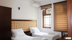 a bedroom with two beds and a window at Vivid Colombo in Colombo