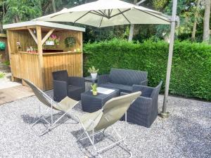 a patio with chairs and a table and an umbrella at Holiday Home Sainte Marie by Interhome in Tosse