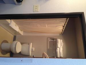 a mirror in a bathroom with a toilet paper dispenser at Absaroka Lodge in Gardiner