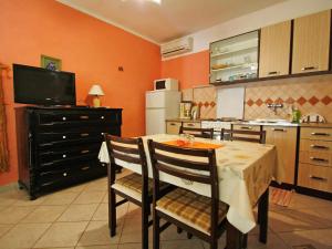 cocina con mesa con sillas y TV en Apartment Dijana-1 by Interhome, en Prigradica