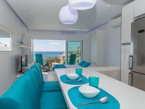 cocina y sala de estar con mesa y sillas azules en Studio Dream View 50m from the beach by Interhome, en Albufeira