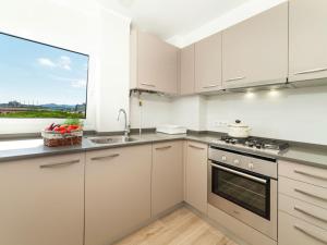 uma cozinha com armários brancos e uma grande janela em Apartment Fanals-6 by Interhome em Platja d'Aro