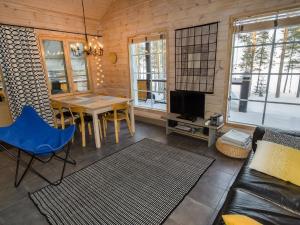uma sala de estar com uma mesa e um sofá em Holiday Home Koliwood a by Interhome em Kolinkylä