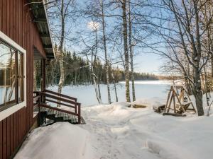 a snow covered porch of a house with a view of a lake at Holiday Home 2235 by Interhome in Savonranta