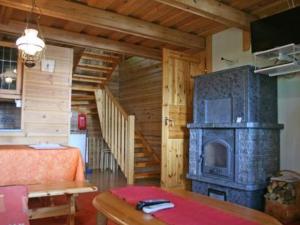 sala de estar con chimenea y escalera en Holiday Home Korvenvalkama by Interhome, en Ahvionniemi