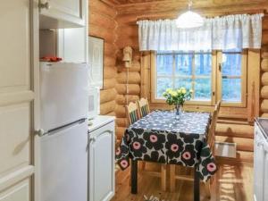 a kitchen with a table with a vase of flowers on it at Holiday Home 6309 by Interhome in Konginkangas