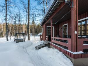 a house in the snow with a bench in front of it at Holiday Home 2234 by Interhome in Savonranta