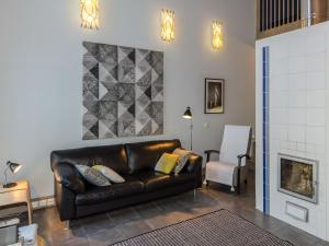 a living room with a leather couch and a fireplace at Holiday Home Koliwood a by Interhome in Kolinkylä