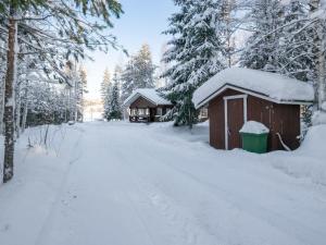 a snow covered cabin on a snow covered road at Holiday Home Villa kontio by Interhome in Savonranta