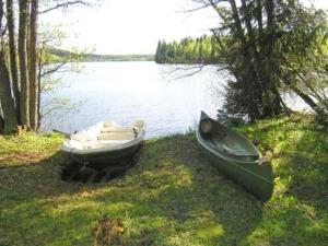 deux bateaux assis sur l'herbe à côté de l'eau dans l'établissement Holiday Home Pitkälahti by Interhome, à Vehmaskylä