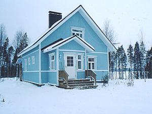 una casa azul en la nieve con árboles en Holiday Home Eteläranta by Interhome en Armisvesi