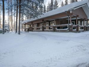 una cabaña de madera en la nieve en el bosque en Holiday Home Villa kontio by Interhome, en Savonranta