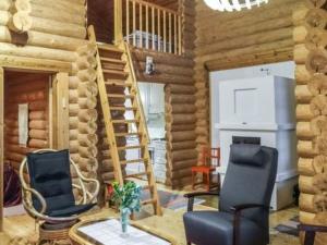 a room with two chairs and a staircase in a log cabin at Holiday Home 6309 by Interhome in Konginkangas +10 photos