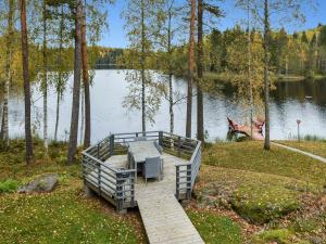 a dock with a table and benches on a lake at Holiday Home Mykkylä by Interhome in Niemi