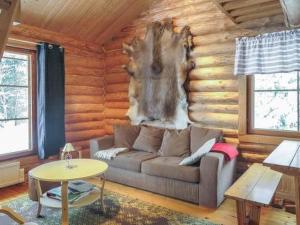 una sala de estar con sofá en una cabaña de madera en Holiday Home Hepolehto by Interhome en Säkinmäki