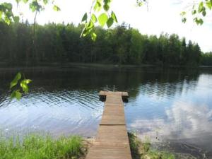 a wooden dock in the middle of a lake at Holiday Home Honkaharju by Interhome in Petäjävesi
