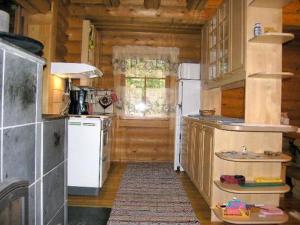 Il comprend une cuisine équipée d'un réfrigérateur blanc et d'une cuisinière. dans l'établissement Holiday Home Aurinkolahti by Interhome, à Taimoniemi