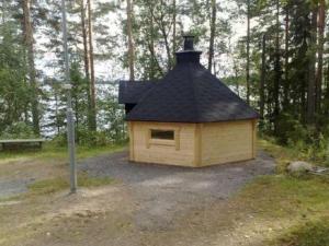 Holiday Home Harakanpesä by Interhome في Saalahti: منزل كلب بسقف أسود في الغابة