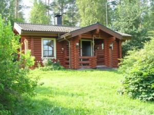 una pequeña cabaña de madera con un patio de césped delante de ella en Holiday Home Petäjäniemi by Interhome, en Saari