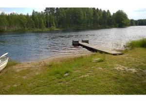 a dock in the middle of a lake with a bench at Holiday Home 5650 by Interhome in Koskenpää
