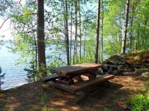 Holiday Home Harakanpesä by Interhome في Saalahti: طاولة نزهة جالسة بجانب تجمع المياه