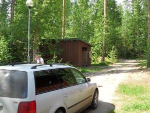 Holiday Home Harakanpesä by Interhome في Saalahti: سيارة بيضاء متوقفة على طريق ترابي بجوار غابة