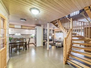 a kitchen and dining room with a wooden staircase in a house at Holiday Home Villanoora b by Interhome in Vuokatti