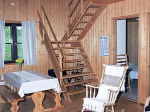 UkkohallaHoliday Home Mustikkainen by Interhome的房间里有一张桌子和几把椅子的木楼梯 更多8张照片