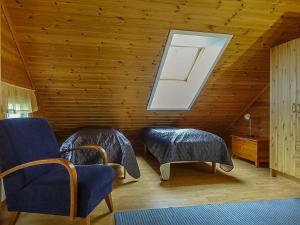 a attic room with two chairs and a skylight at Holiday Home Aallotar kuiskaus by Interhome in Paltamo