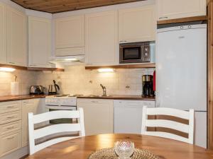アカスロンポロにあるHoliday Home Kuerkartano 2-sulo by Interhomeのキッチン(白いキャビネット、テーブル、椅子付)
