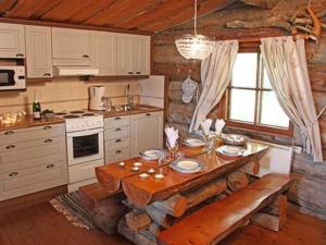 a kitchen with a wooden table in a cabin at Holiday Home Kopinkallio 3 by Interhome in Pätiälä
