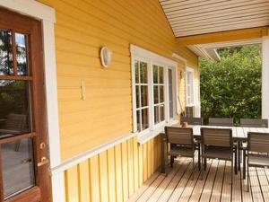 una terrazza con tavolo e sedie su una casa di Holiday Home Keltavuokko by Interhome a Sipsiö