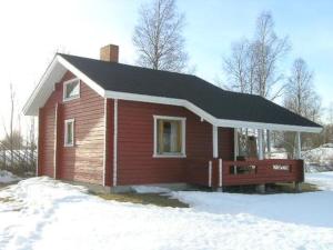 a small house with a black roof in the snow at Holiday Home Hilla by Interhome in Jokijärvi
