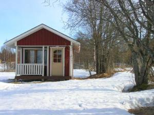 una pequeña casa roja con nieve en el suelo en Holiday Home Karpalo by Interhome, en Jokijärvi