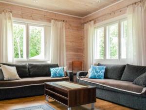 a living room with two couches and a coffee table at Holiday Home Tervaleppä by Interhome in Torvoila