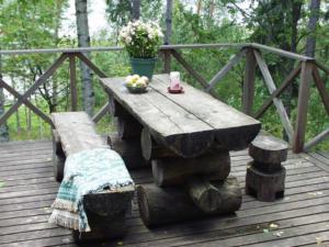 PätiäläにあるHoliday Home Alppimaja by Interhomeの木製のデッキの上に置かれた木製のテーブルとベンチ