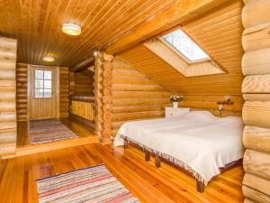 a bedroom with a bed in a log cabin at Holiday Home Karhulinna by Interhome in Miehoila