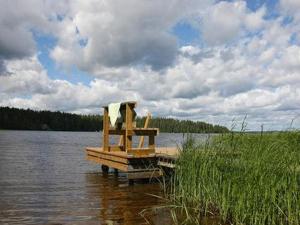 un banc assis sur un quai sur un lac dans l'établissement Holiday Home Kultaranta by Interhome, à Pätiälä