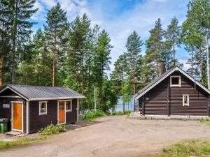 Kuusjärvi的住宿－維庫林偉蘭塔度假屋，泥路旁树林中的小屋