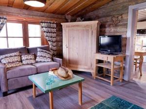 a living room with a couch and a tv in a cabin at Holiday Home Peltotupa by Interhome in Pätiälä