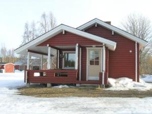 a small red house with snow in front of it at Holiday Home Hilla by Interhome in Jokijärvi