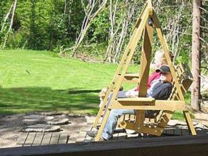 Ein Mann und eine Frau sitzen in einer Schaukel in der Unterkunft Holiday Home Pikkutupa by Interhome in Hyyrylä