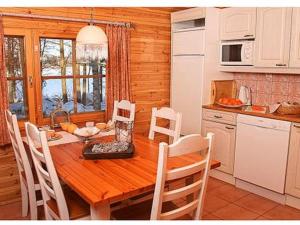 a kitchen with a wooden table and chairs in a room at Holiday Home Mäntyniemi by Interhome in Pätiälä