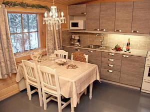 a kitchen with a table with chairs and a dining room at Holiday Home Metsäpirtti by Interhome in Pätiälä