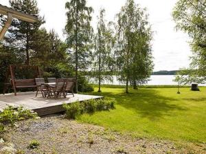 a patio with a table and a bench in a park at Holiday Home Keltavuokko by Interhome in Sipsiö