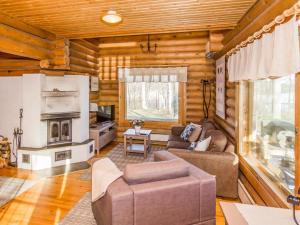 a log cabin living room with a couch and a fireplace at Holiday Home Karhulinna by Interhome in Miehoila