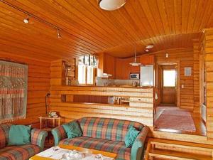 ein Wohnzimmer mit 2 Sofas und einer Küche in der Unterkunft Holiday Home Petäjäinen by Interhome in Sipsiö