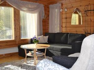 a living room with a black couch and a table at Holiday Home Rantamaja by Interhome in Kittilä