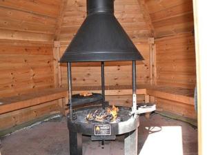 a large black stove in a room with wooden walls at Holiday Home Vuoristomaja by Interhome in Kittilä
